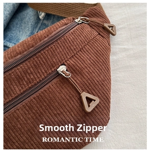 Detail of smooth double zippers and brown corduroy texture on this casual crossbody bag