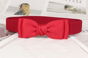 Detailed view of elegant red bow elastic waist belt for dresses on a magazine background