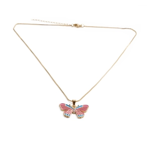 Detailed macro view of butterfly pendant with pink and blue enamel on gold plated chain
