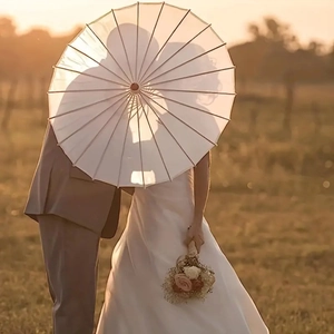 Detail of a white paper parasol with bamboo ribs for romantic outdoor wedding photography