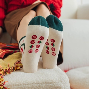 Close-up of cotton socks showing festive Chinese characters and persimmon pattern on soles