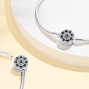 Macro detail of S925 silver snake chain clasp with blue zircon stars and compass