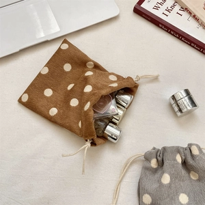 Close-up of small corduroy drawstring bags with white polka dots for cosmetic storage