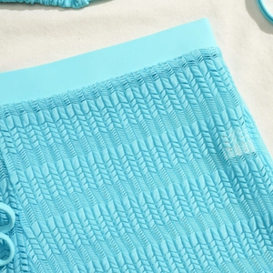 Macro view of light blue three-piece bikini with chevron mesh texture and waistband detail
