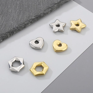 Detailed view of gold and silver heart, star, and hexagon charms for DIY jewelry making