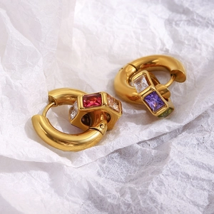 Vue macro des boucles d'oreilles géométriques en or 18K et zircons multicolores