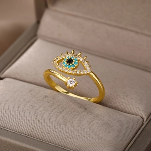 Macro shot of gold angel eye open ring with blue stones in a velvet jewelry box