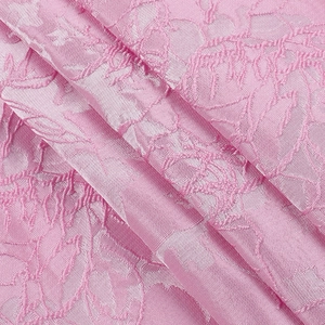 Vue macro du tissu jacquard rose avec broderie florale élégante et texture soyeuse
