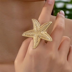 Gold starfish ring with grainy texture worn on finger for summer beach vacation style