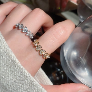 Detailed close-up of leaf vine rings with zircon stones and micro pearls on fingers