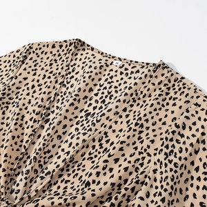 Detail of deep V-neckline and leopard print satin fabric texture on a women's dress