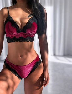 Détail d'un ensemble de lingerie en velours bordeaux et dentelle noire sous la lumière