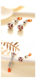 Detailed crown ear stud featuring red stones and orange teardrop pendant in silver steel