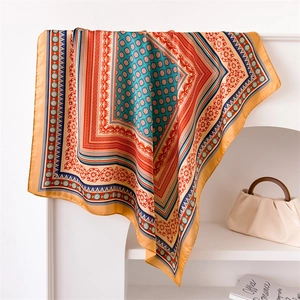 Close-up of geometric floral pattern on a smooth silk-like scarf with elegant drape