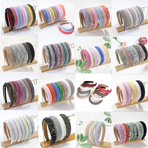 Detail view of various thick padded headbands with colorful rhinestones and pearls