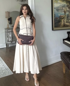Détail d'une robe midi sans manches crème avec liseré noir et design à col boutonné unique