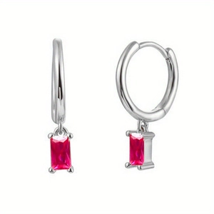 Détail de boucles d'oreilles C argentées avec un pendentif rectangle en pierre rouge