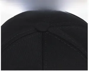 Close-up of black cotton baseball cap top showing stitching and crown button detail