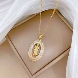 Détail du collier doré avec pendentif ovale en nacre, portrait et zircons étincelants