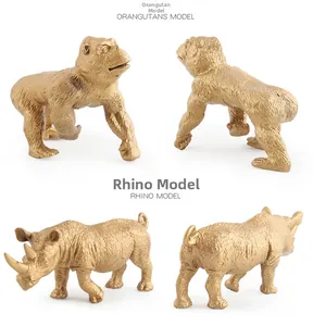 Dettaglio di statuette dorate di rinoceronte e orangutan con texture realistica