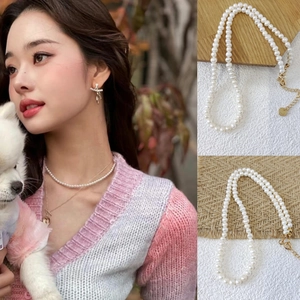 Detail of freshwater pearl necklace set with gold heart pendant and matching earrings