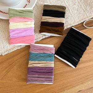 Detail shot of multi-color high-elasticity fabric hair ties on cardboards with textures