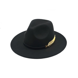 Detailed view of black wool fedora featuring golden leaf metal accent and leather band