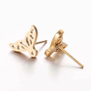 Detailed macro view of gold hollow fish tail stud earrings with minimalist metal craftsmanship