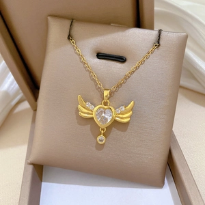 Detailed close-up of a heart-shaped pendant with wings on a velvet jewelry box display