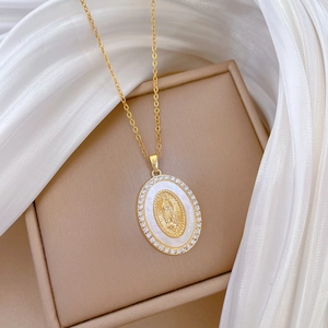Macro shot of gold-plated titanium necklace with crystal halo and white shell portrait