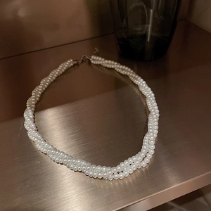 Elegante collana di perle intrecciate a più strati con finitura lucida su superficie