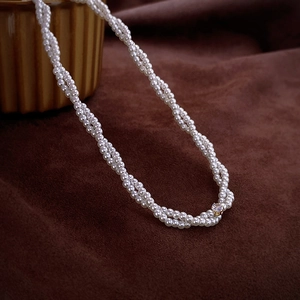 Detail of elegant double-strand pearl choker necklace with zircon on brown velvet