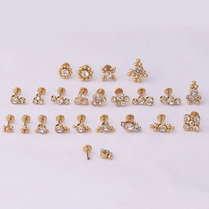 Gros plan sur les piercings labret 16G dorés avec filetage interne et zirconiums clairs