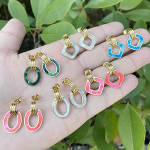 Detailed view of colorful geometric stainless steel earrings in green and pink hues