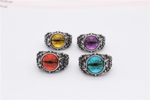 Detailed view of gothic bat-style rings with colorful eye gemstones in vintage silver