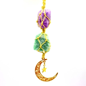 Handmade amethyst crystal pendant with yellow woven net and moon star charms on white background