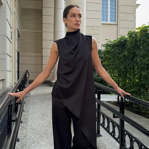 Detail of elegant black satin sleeveless top with asymmetric hem and draped collar