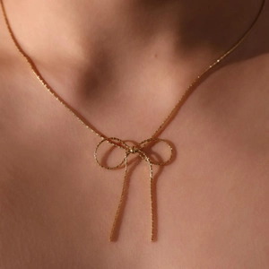 Elegant gold bow necklace on model, minimalist titanium steel jewelry for women