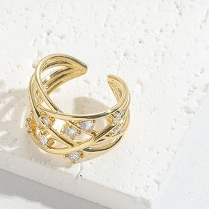 Detailed view of luxury gold ear cuff with layered design and sparkling zircons on stone