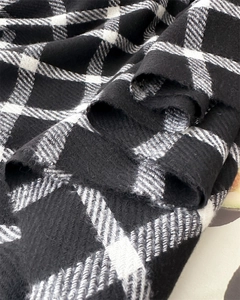 Detailed macro view of the soft woven texture on this black and white plaid scarf fabric