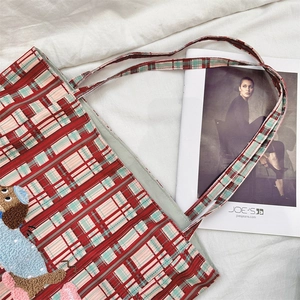 Close-up of a red and blue plaid tote bag featuring a cute 3D cartoon puppy patch embroidery