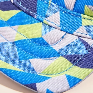 Macro del tessuto in tela con motivi geometrici blu e verdi sulla visiera del cappello cane