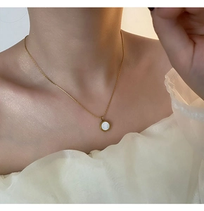 Close-up of mother-of-pearl pendant on a 18K gold-plated titanium steel chain