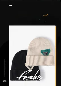 Close-up of thick knitted winter hats with ribbed texture and decorative Happy fabric patches