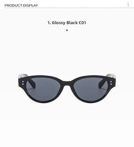 Close-up of bright black cat-eye sunglasses with silver metal rivets on the frame corner