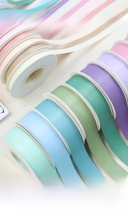 Close-up of matte cotton ribbons in pastel Morandi colors for gift wrapping and flower boxes