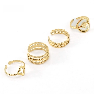 Detail of four-piece gold plated open ring set with woven and floral designs