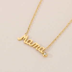 Close-up of golden MAMA pendant necklace with sparkling crystal detail for Mother's Day