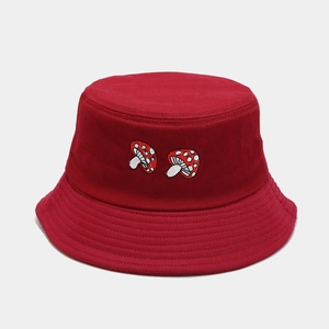 Detail of dark red canvas bucket hat featuring two red and white mushroom embroidery icons