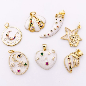 Vue détaillée de pendentifs dorés en émail blanc sertis de zircons multicolores